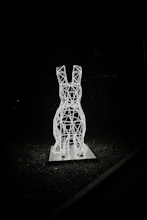A futuristic rabbit illuminated by neon lights in a dark urban setting.