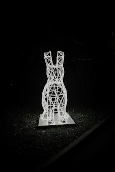 A futuristic rabbit illuminated by neon lights in a dark urban setting.