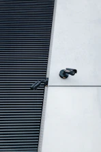 a pair of black shoes sitting on the side of a building