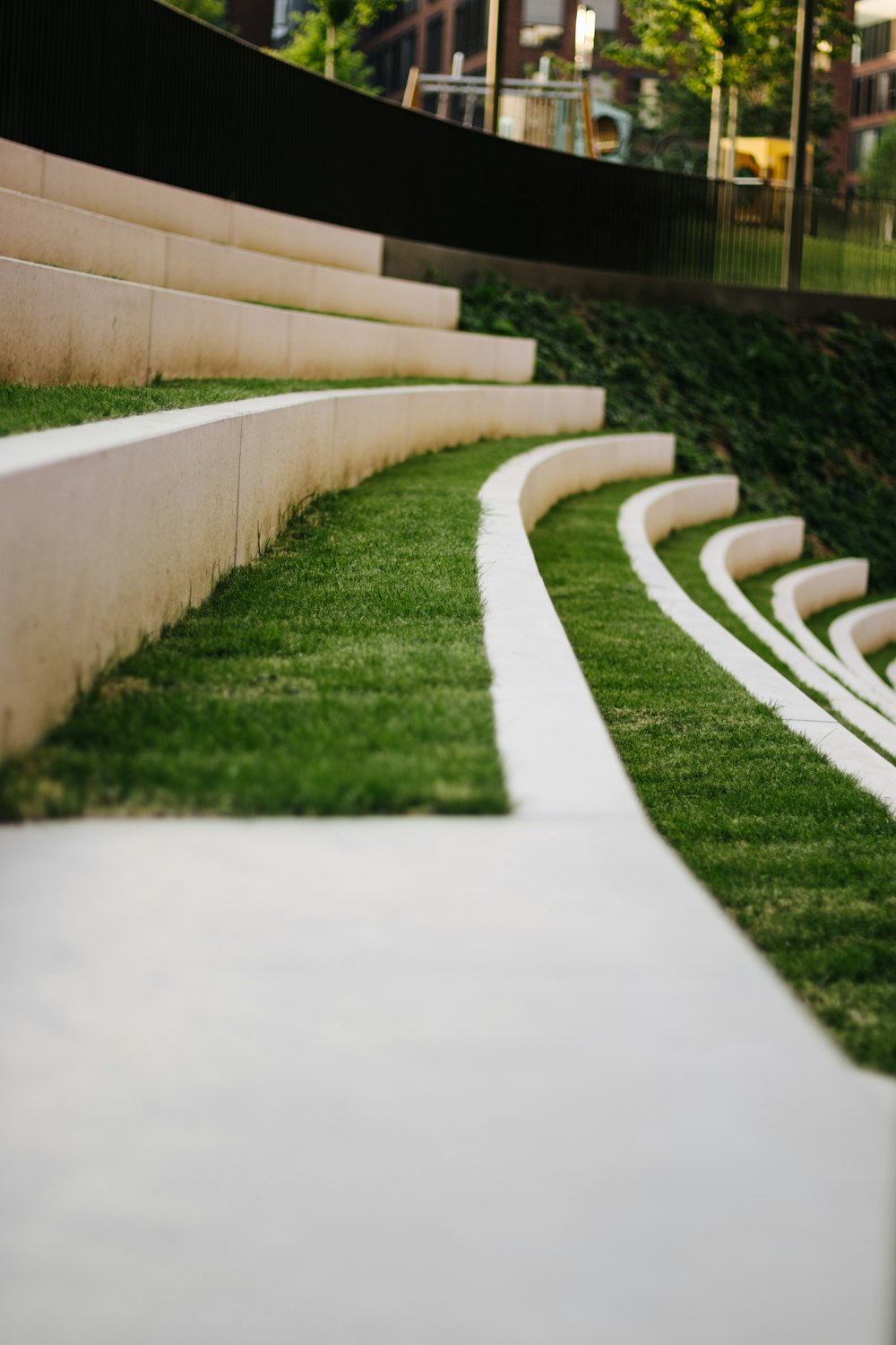 a row of white concrete steps next to a lush green field