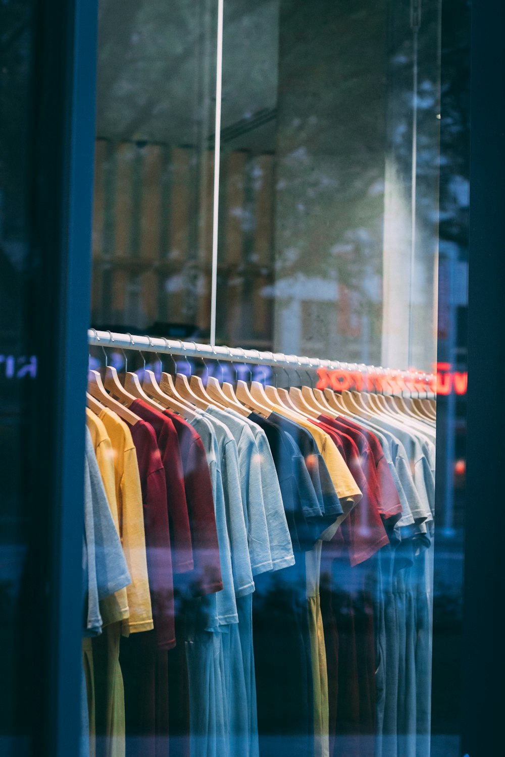 a bunch of shirts are hanging in a window