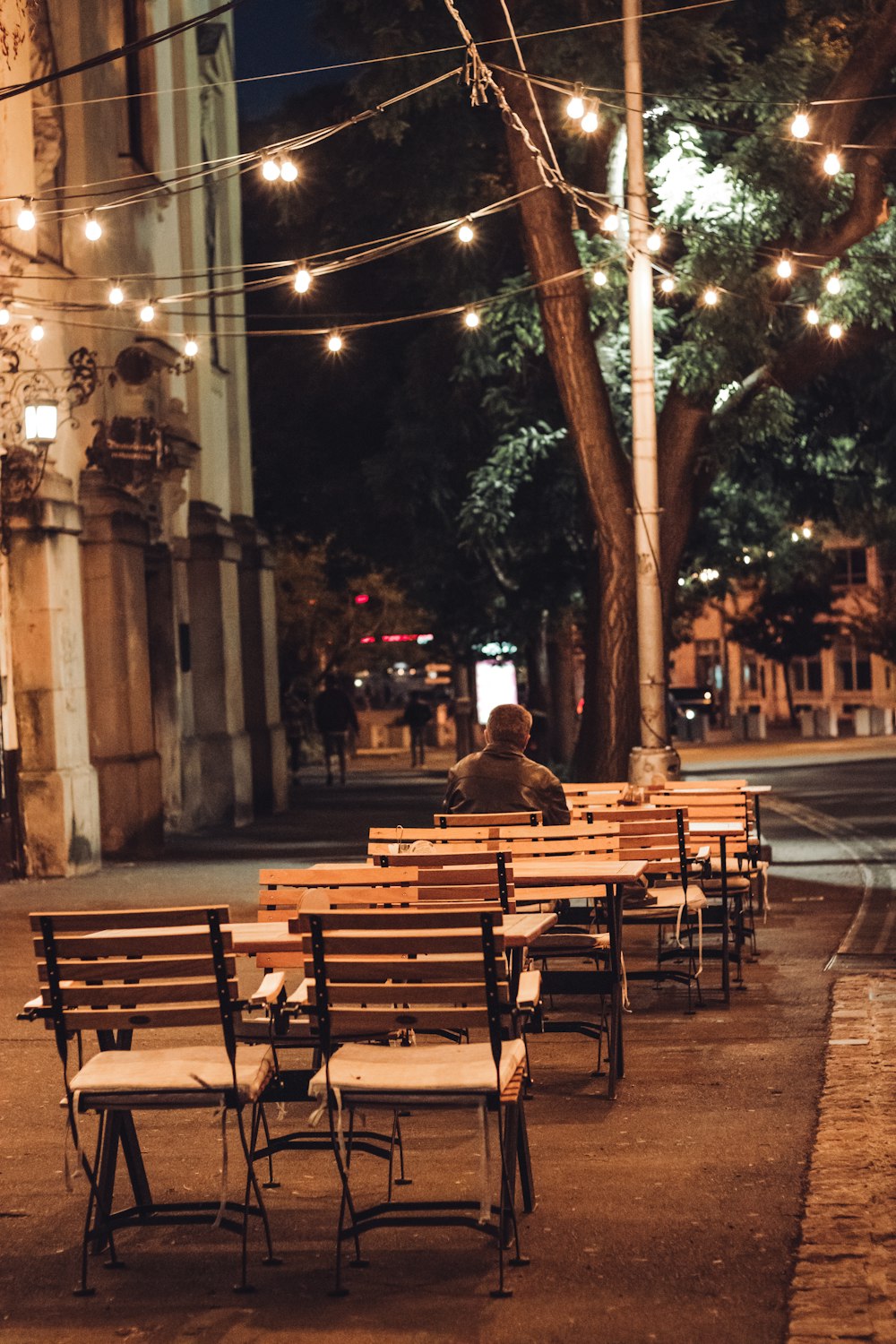 a row of wooden benches sitting on top of a sidewalk