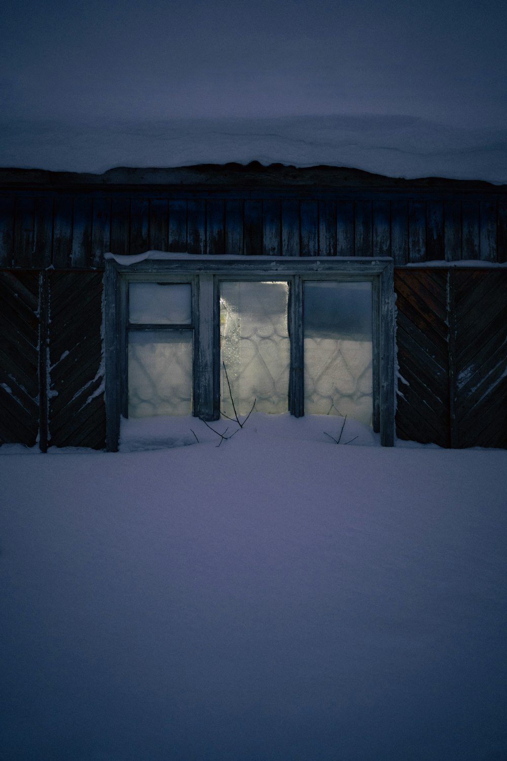 a snow covered yard with a door and window