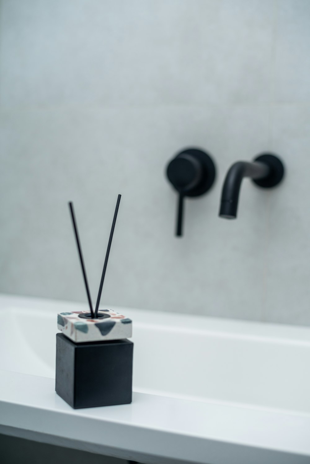 a black candle holder sitting on top of a white counter