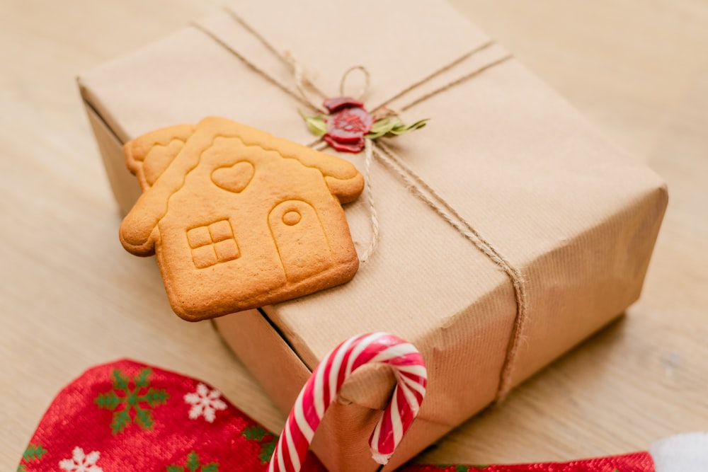 a present wrapped in brown paper with a gingerbread cookie in the shape of a