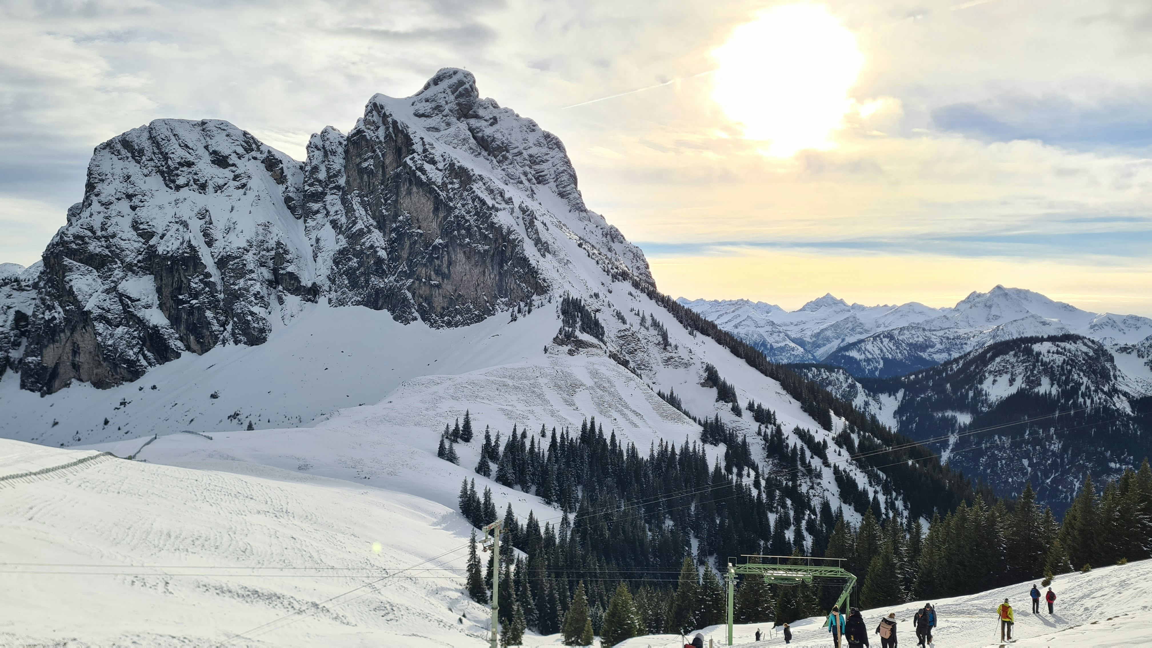 a group of people riding skis down a snow covered slope