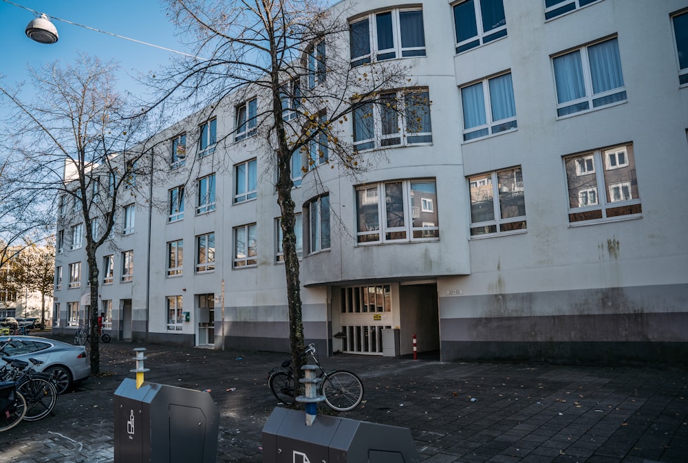 a white building with many windows and bicycles parked in front of it