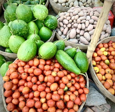 a pile of baskets filled with lots of fruits and vegetables