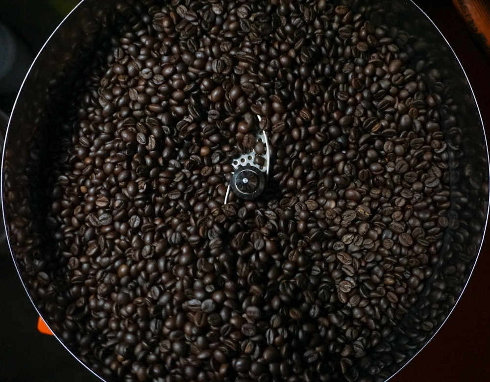 a pan filled with coffee beans on top of a stove