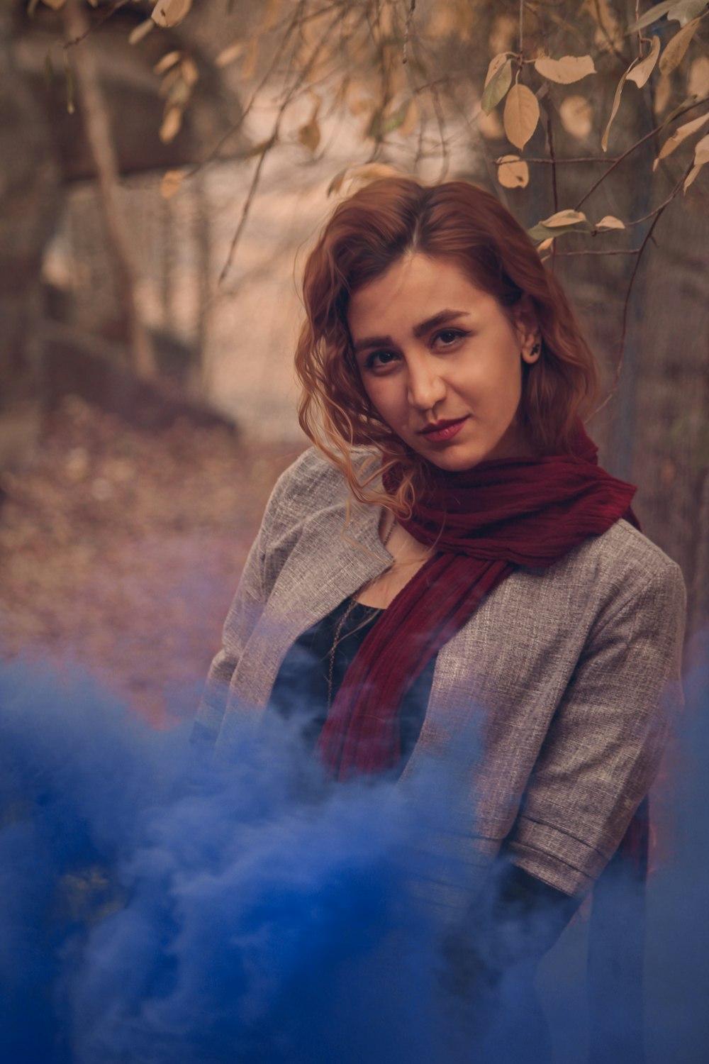 a woman standing in front of a blue smoke bomb