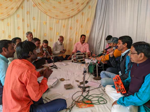 Colleagues gathered in a music circle, playing instruments and sharing laughs during a jamming session.