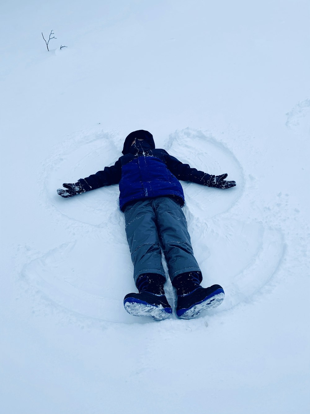 a person laying in the snow on their back