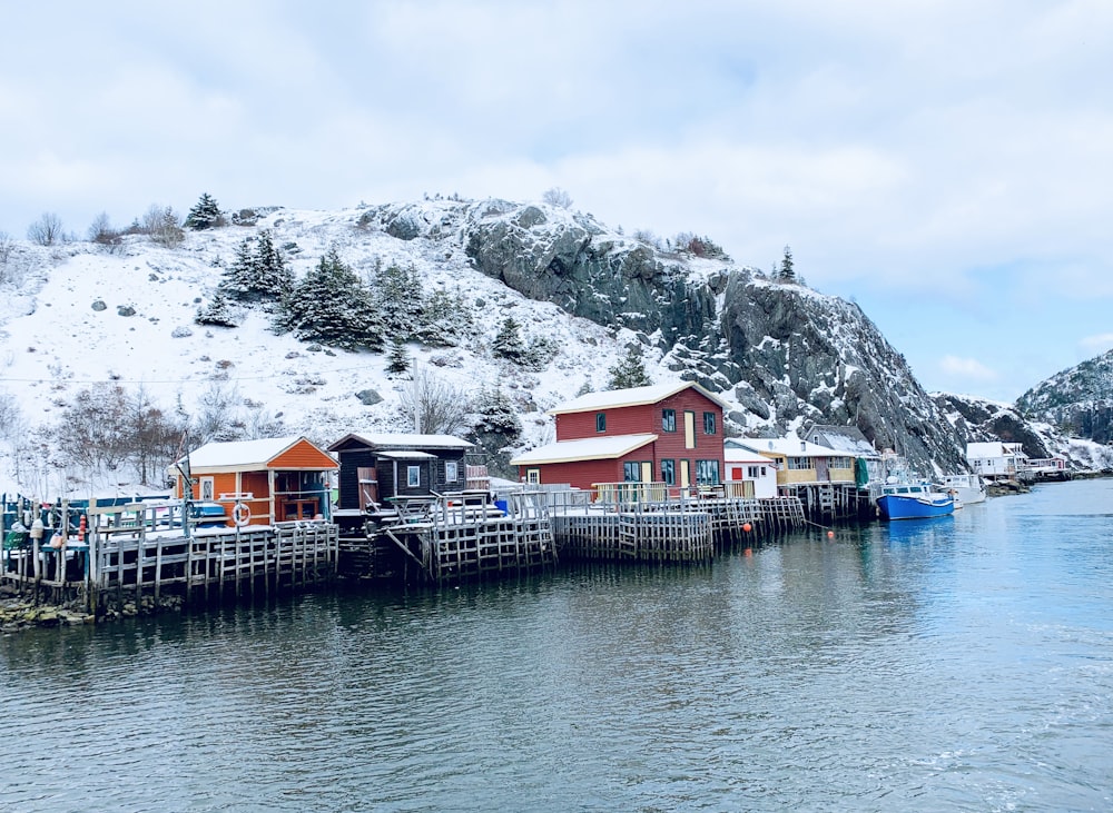 a group of houses sitting on a pier next to a body of water