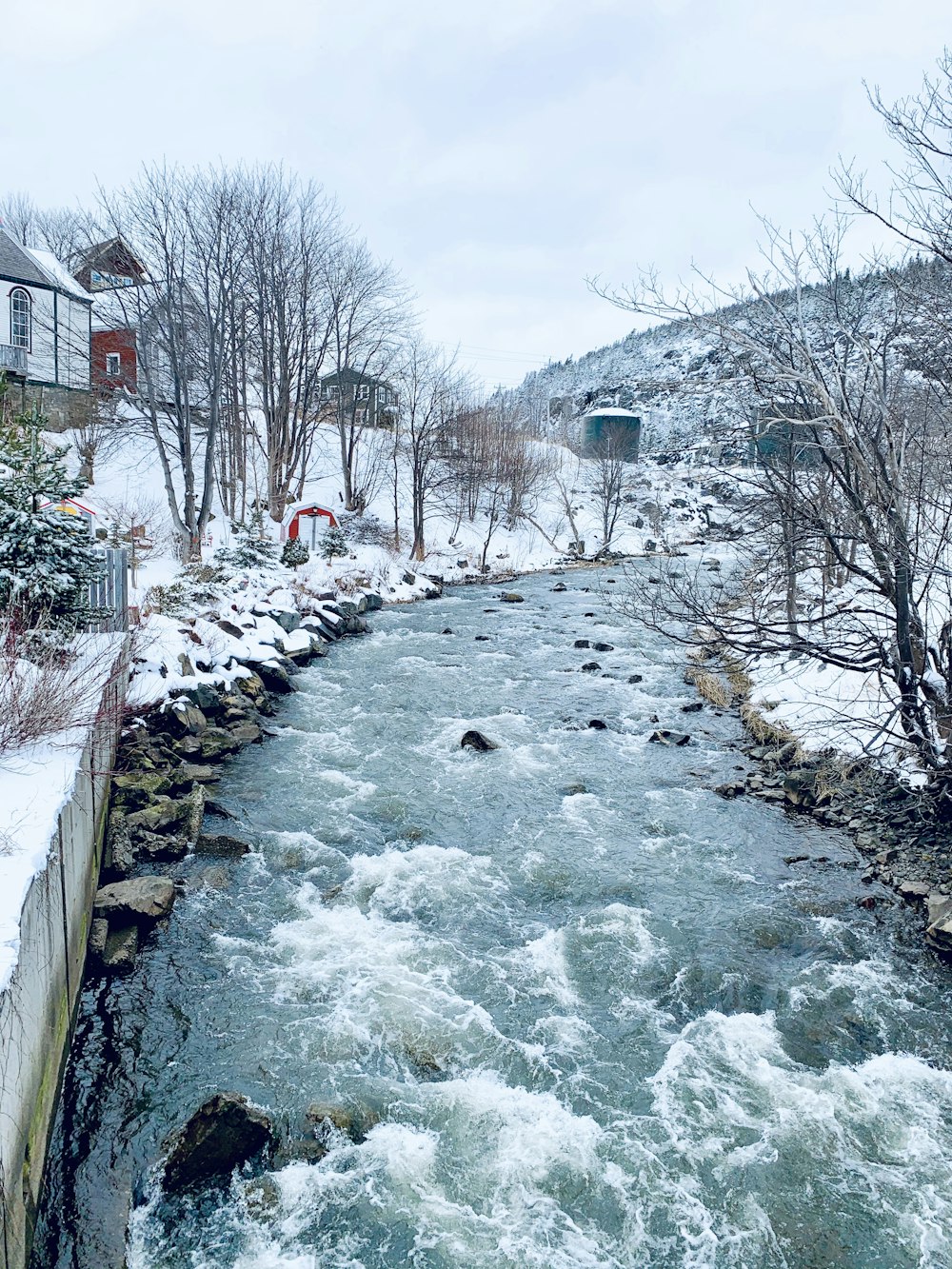 Ein Fluss, der durch einen schneebedeckten Hang fließt