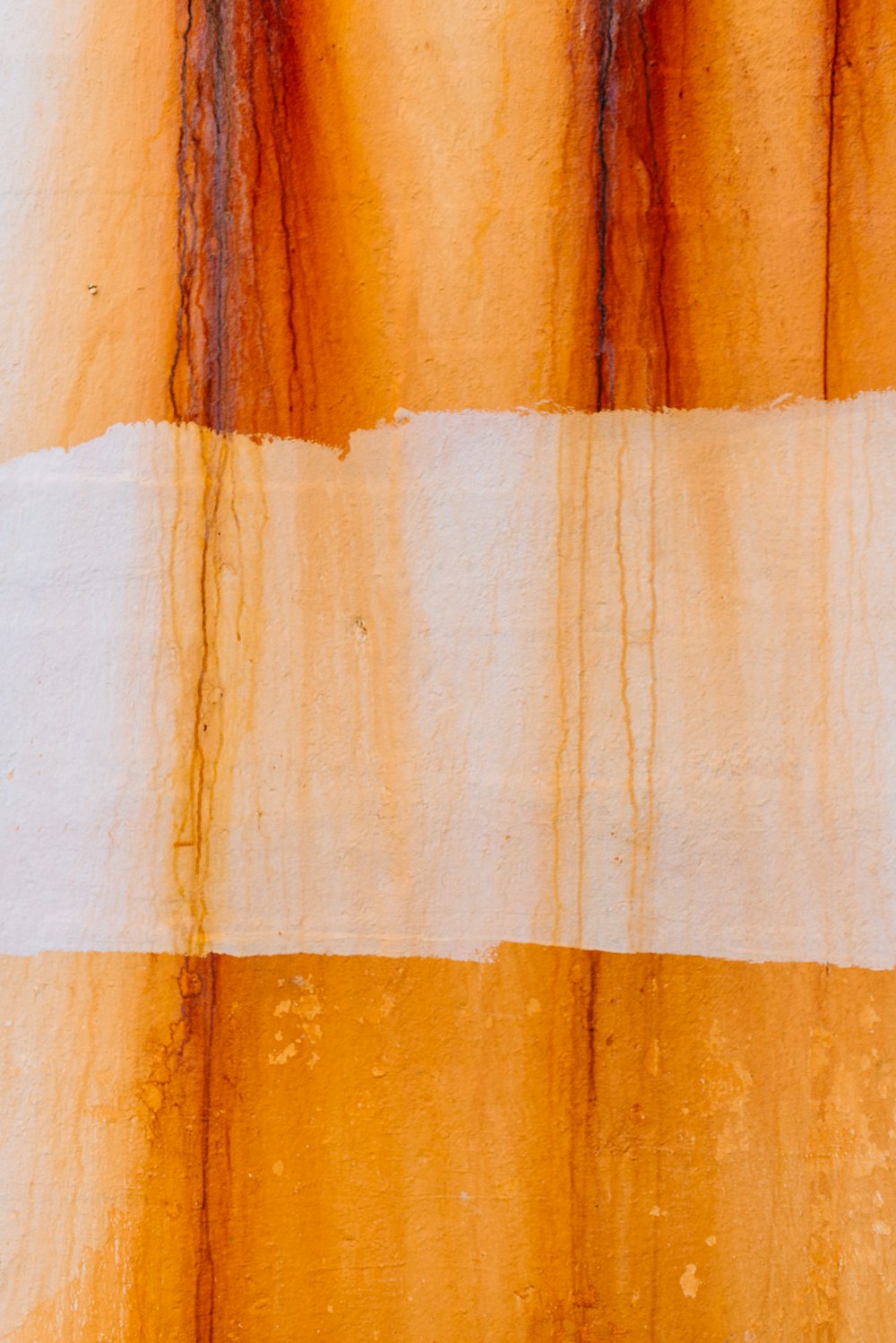 an orange and white striped curtain with a bird perched on it