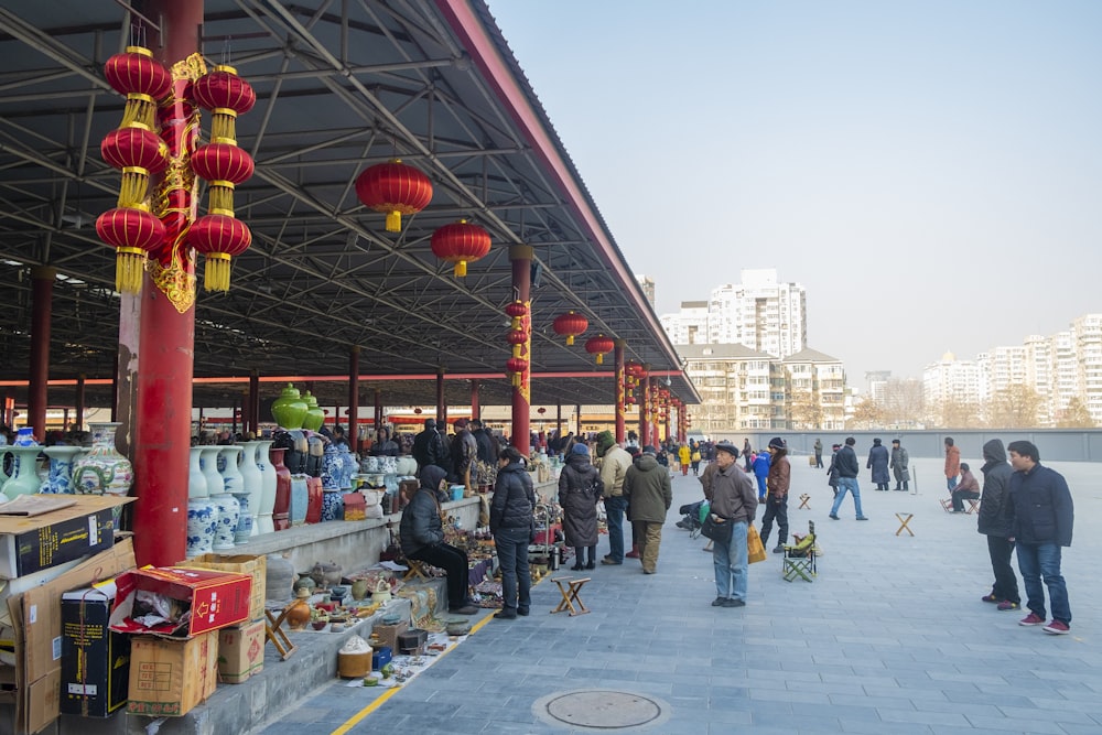 a group of people standing around a covered area