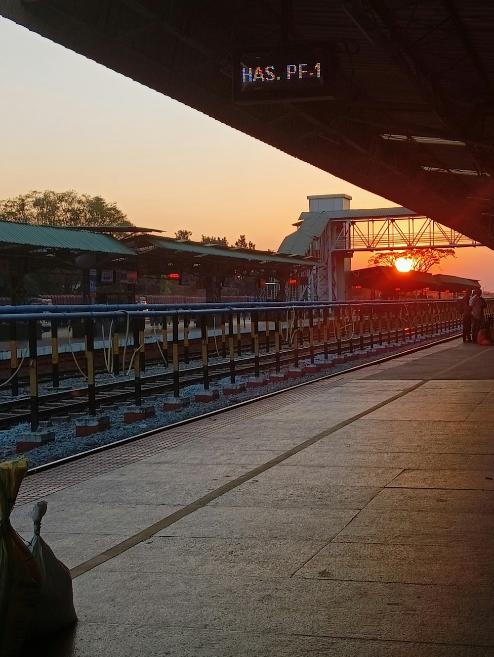 the sun is setting at the train station
