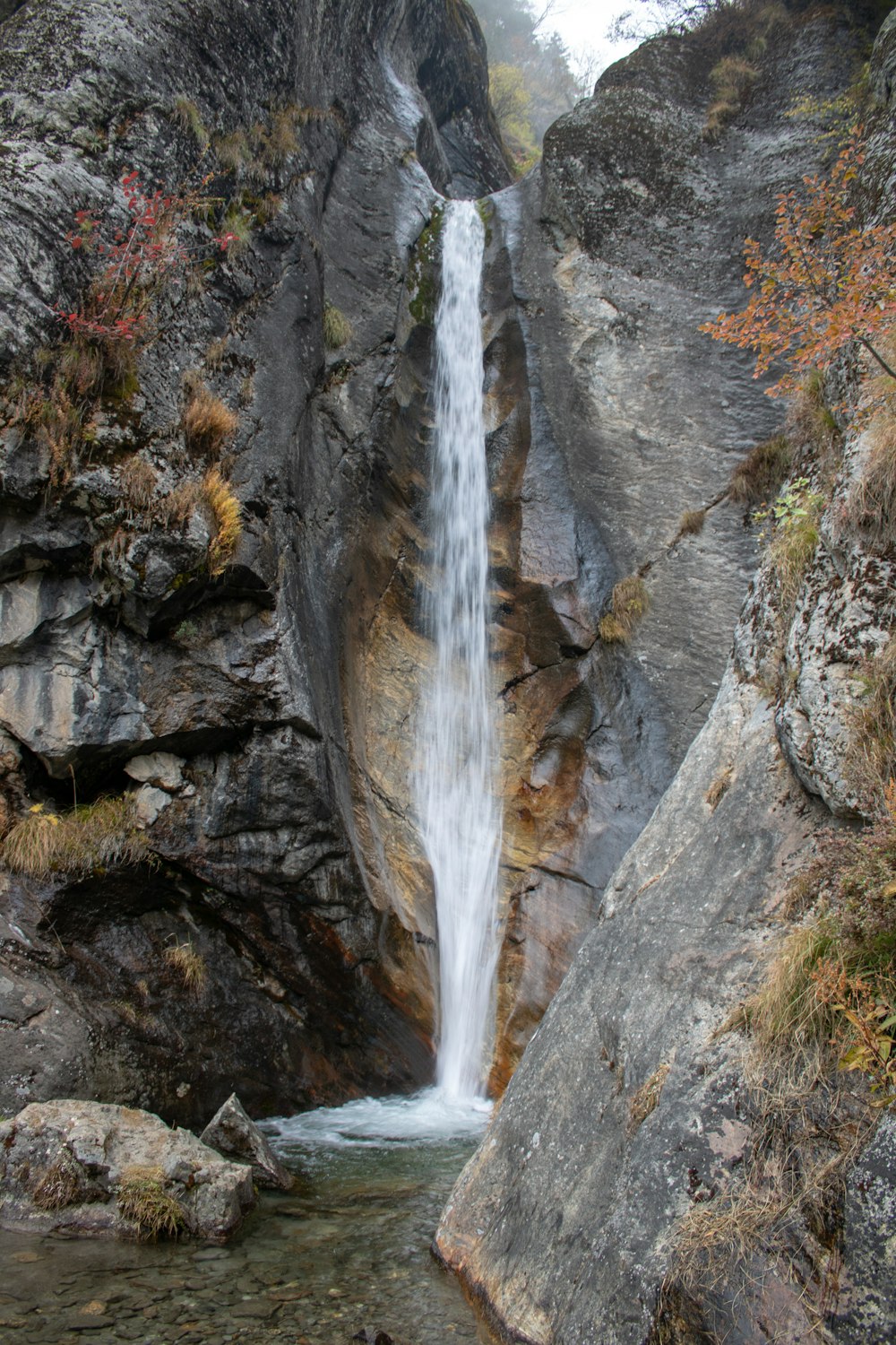 a waterfall is coming out of the rocks into the water