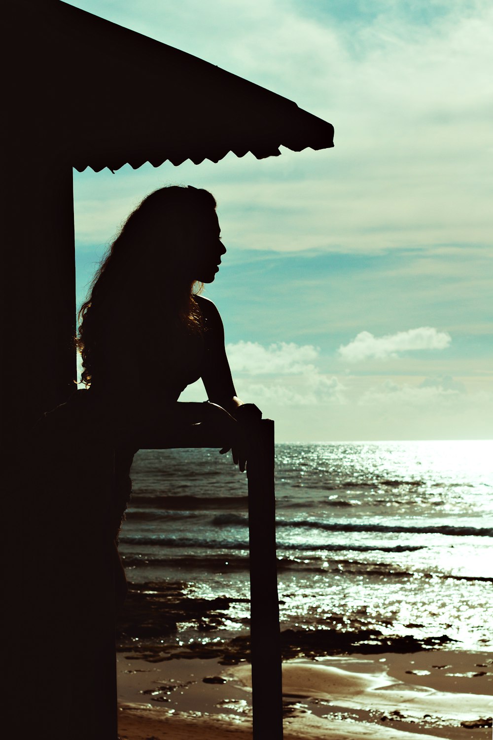 a woman standing on a beach next to the ocean