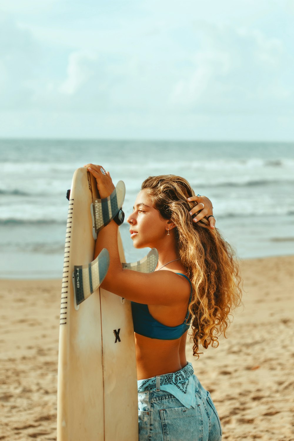 a woman holding a surfboard on a beach