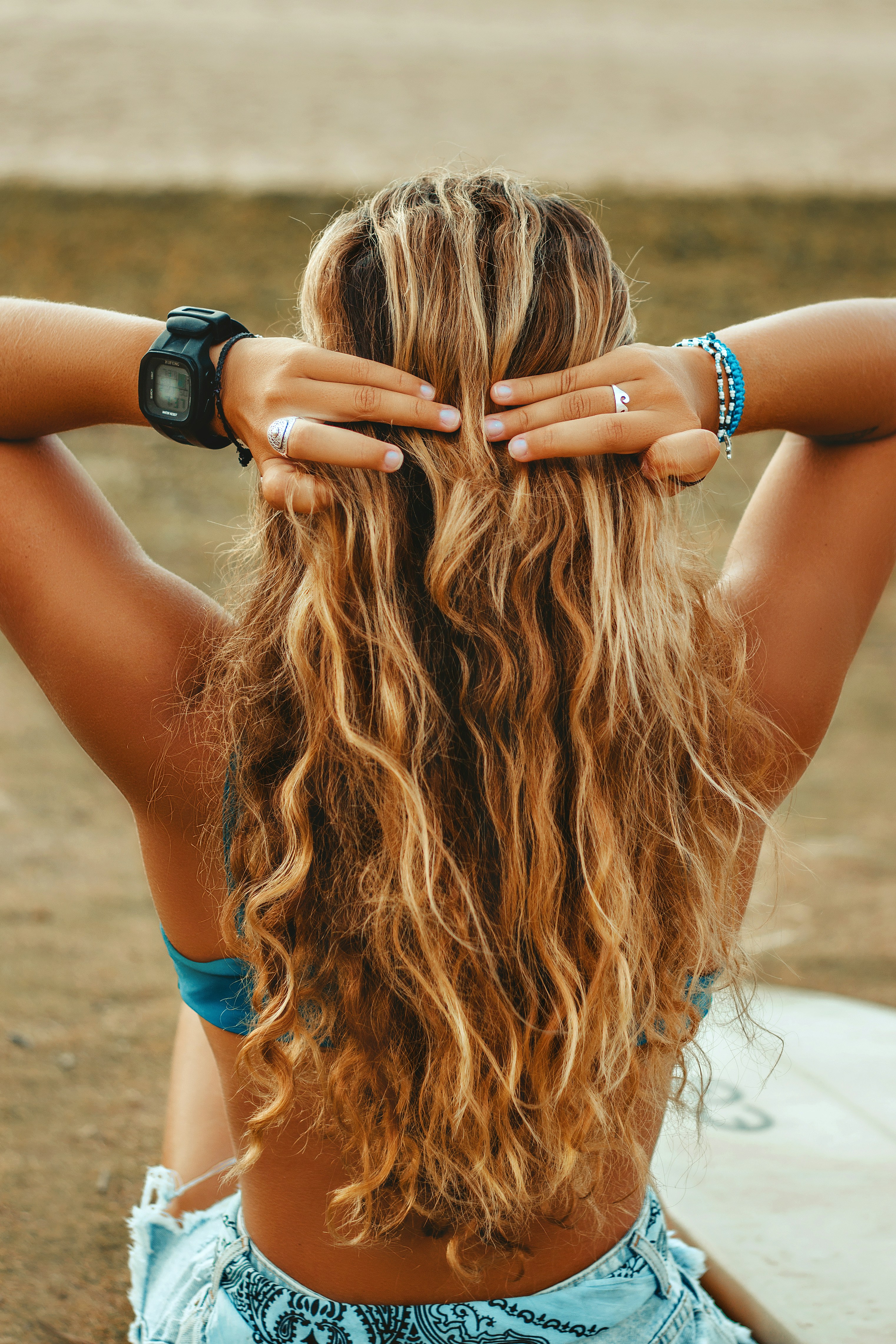 Woman with wavy, sun-kissed blonde hair styled in beach waves.
