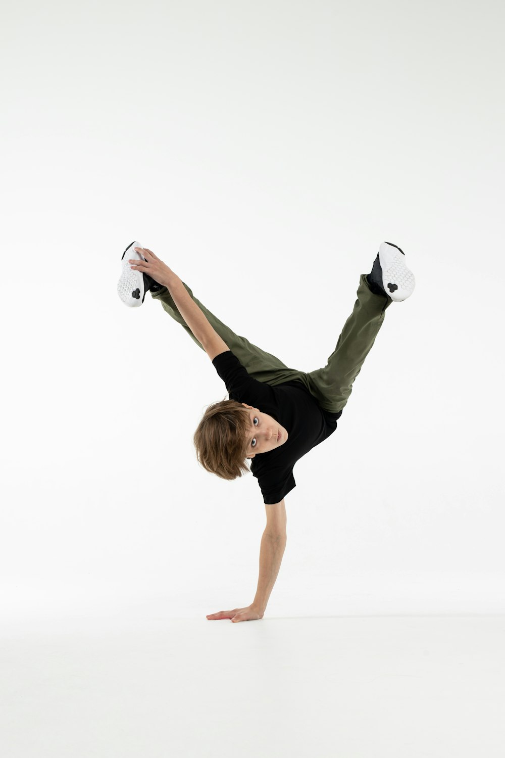 a young man doing a handstand on one leg
