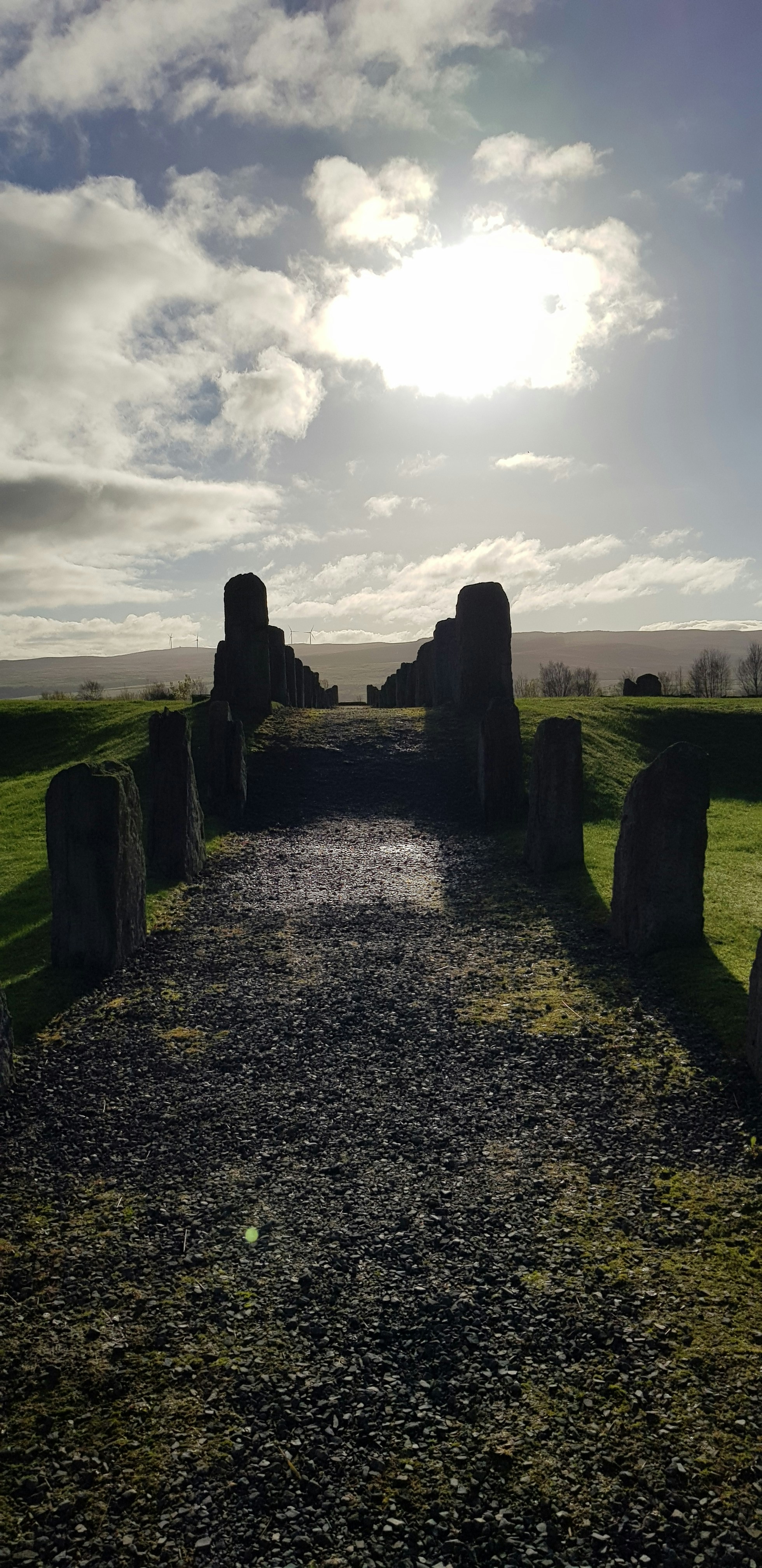 the sun is shining over the stonehenge in the field