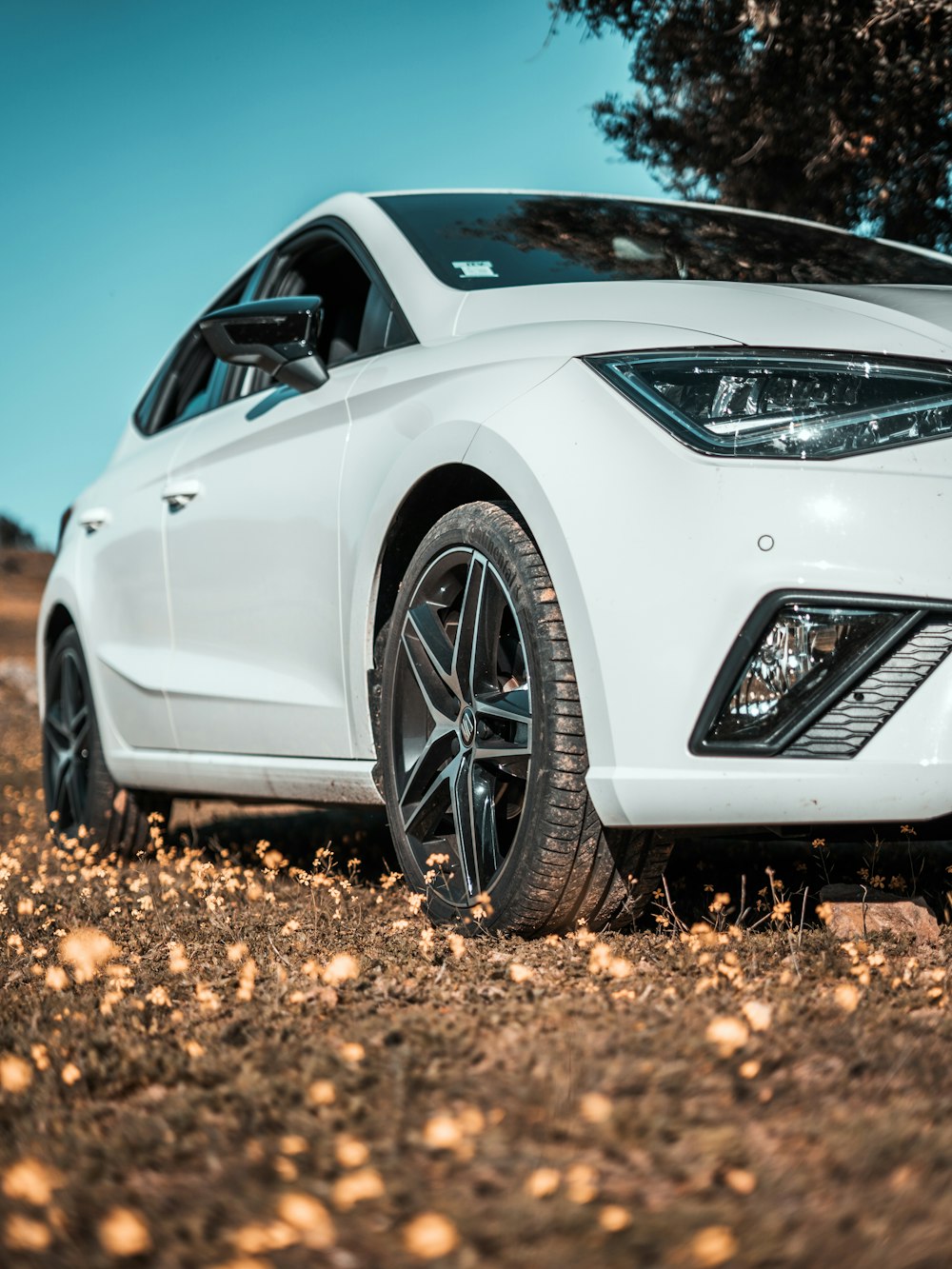 a white car is parked in a field