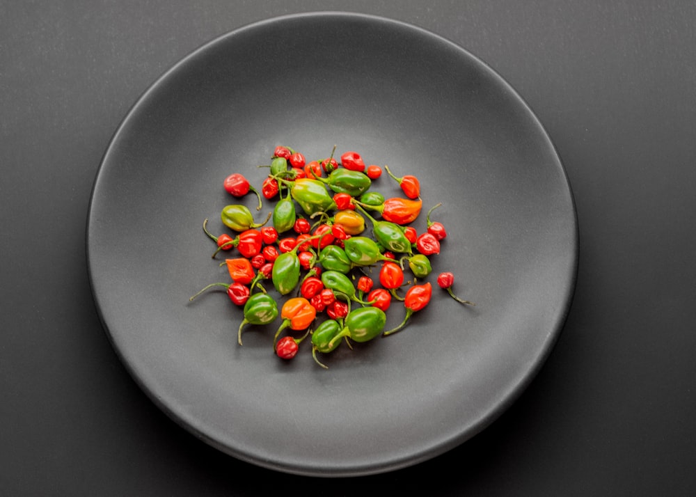 a plate with some red and green peppers on it