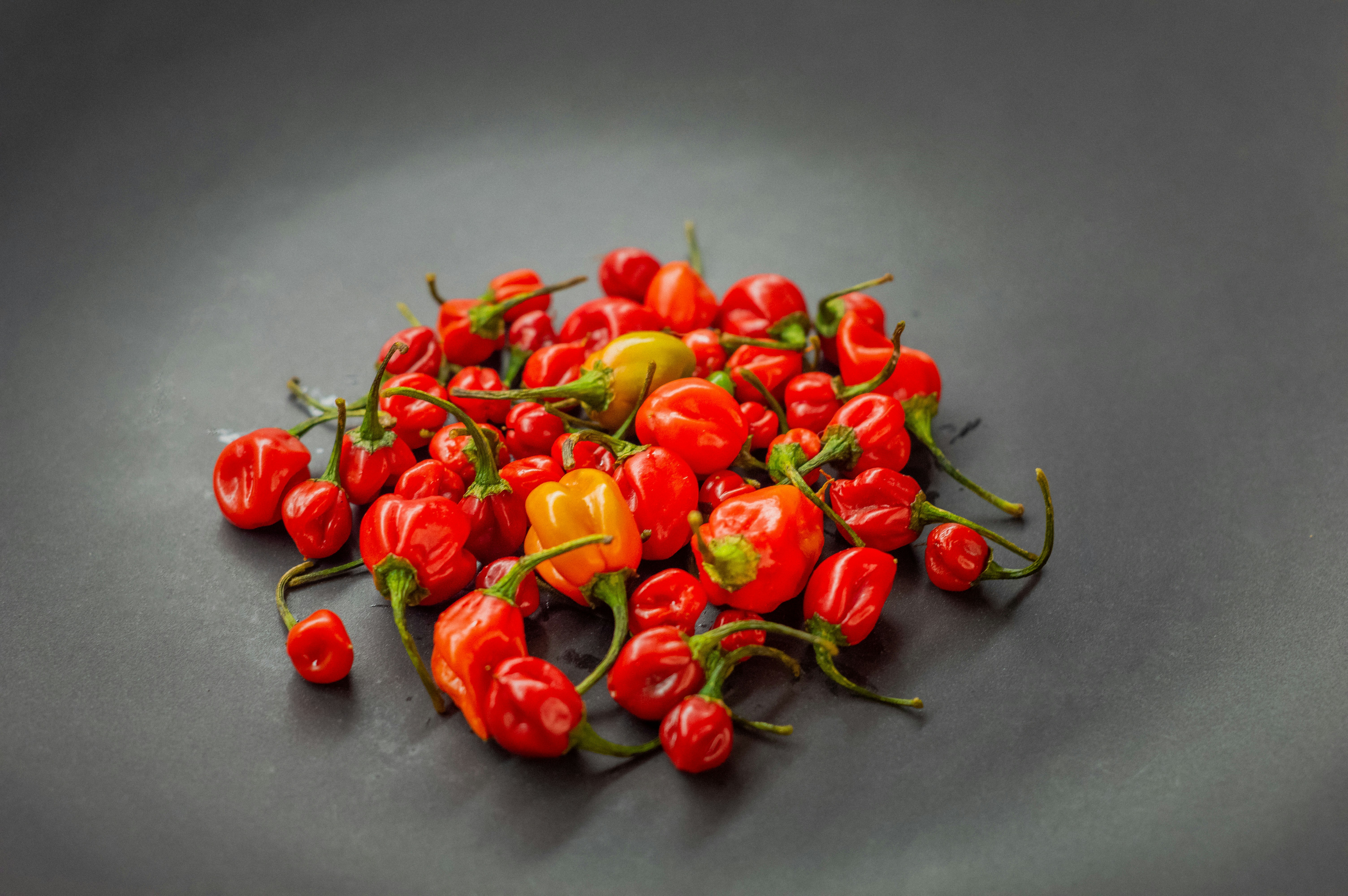 a pile of red and yellow peppers on a black plate