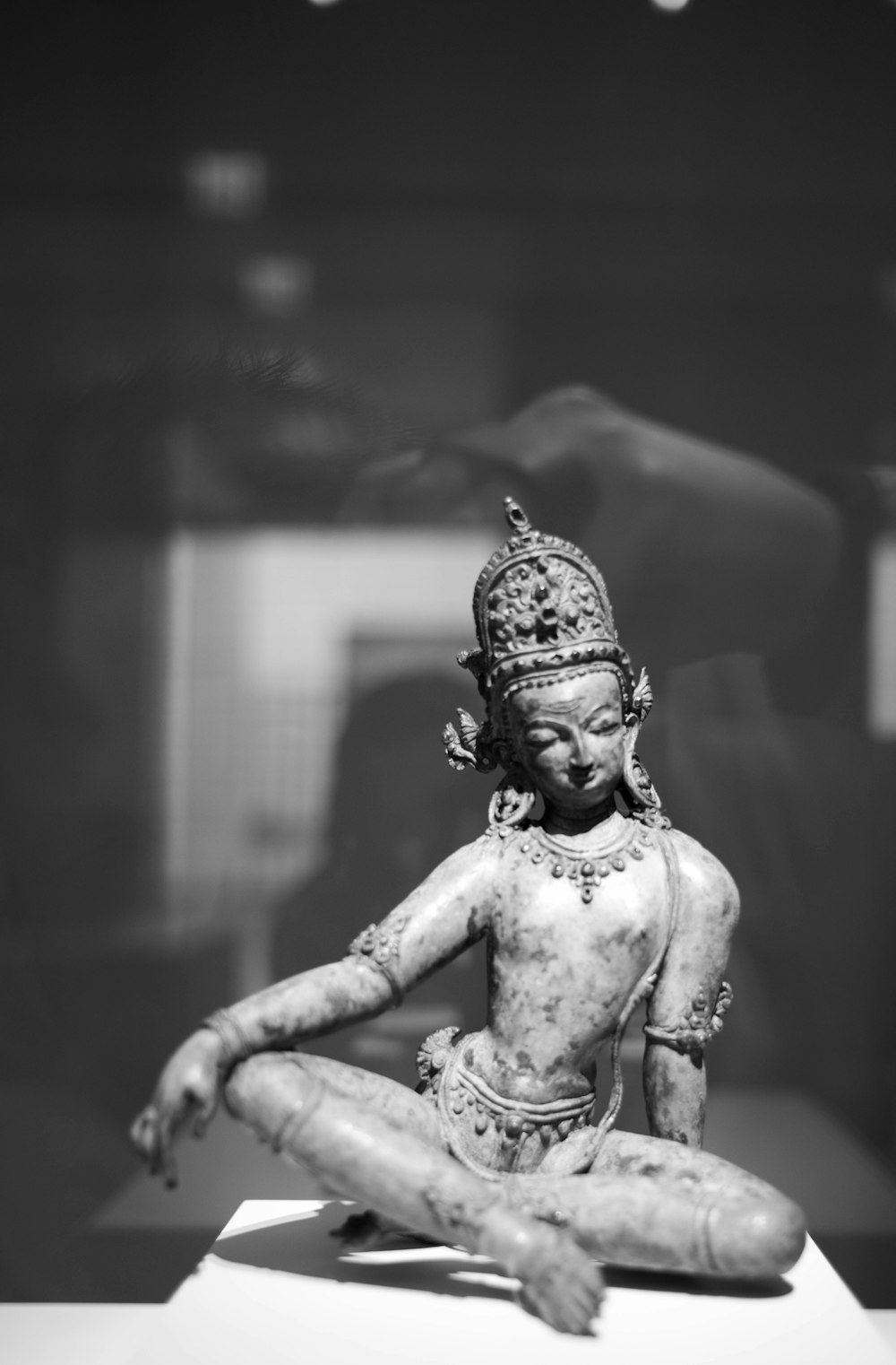 a statue of a person sitting on a table