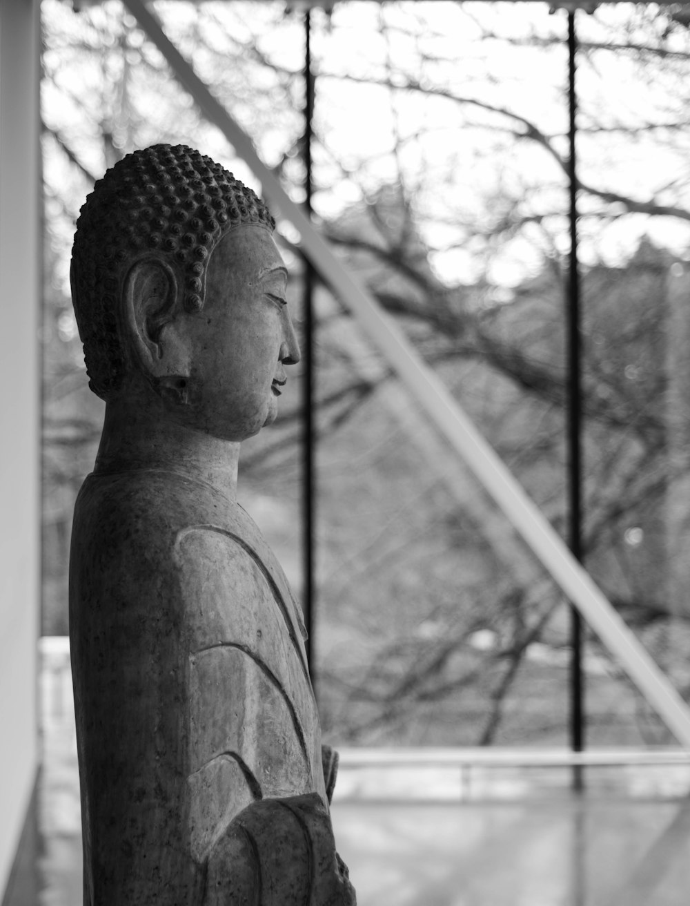 uma foto em preto e branco de uma estátua de Buda