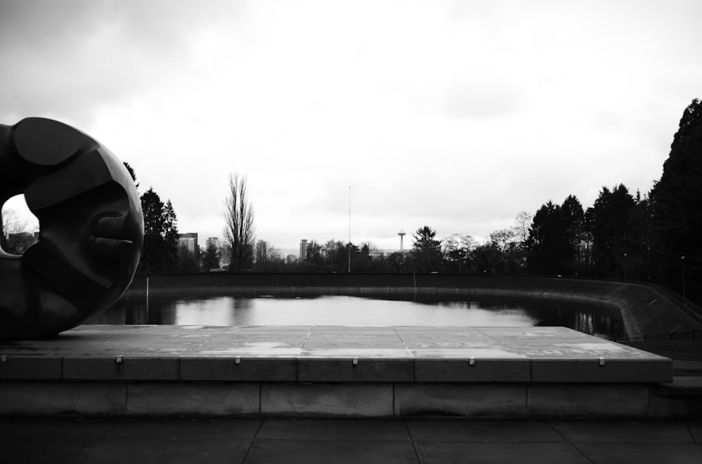 Una foto in bianco e nero di una scultura in un parco