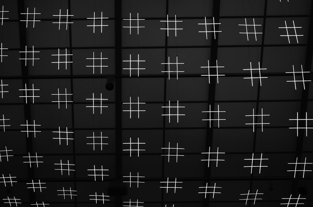 uma foto em preto e branco de uma parede com cruzes sobre ela