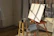 A cozy art studio corner with brushes and canvases bathed in natural light.