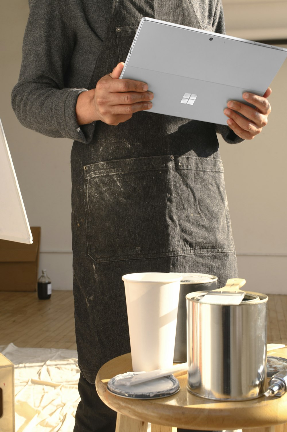 a man in an apron is holding a tablet