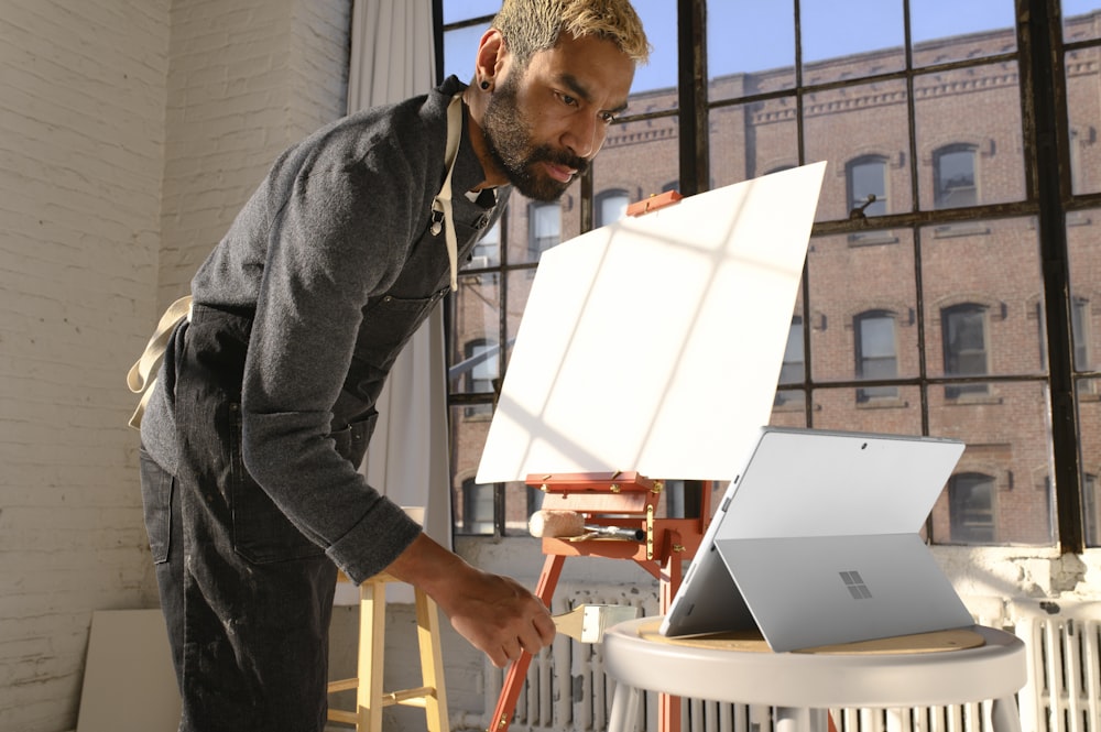 a man standing in front of a laptop computer