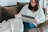 A person enjoying a video on a laptop with a cozy atmosphere.