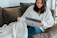 A person enjoying a video on a laptop with a cozy atmosphere.
