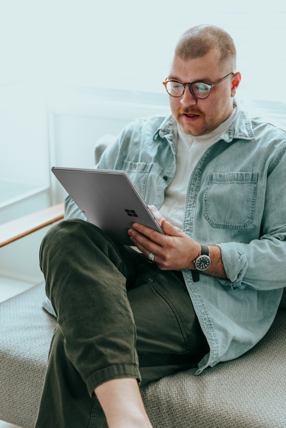 a man sitting on a couch using a laptop computer