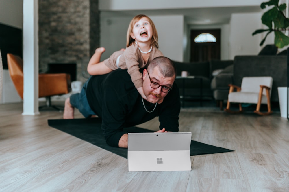 a man and a little girl playing with a laptop