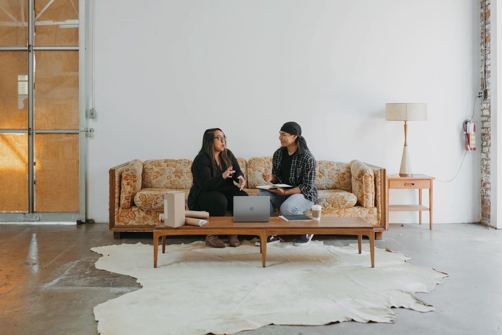 a couple of women sitting on top of a couch