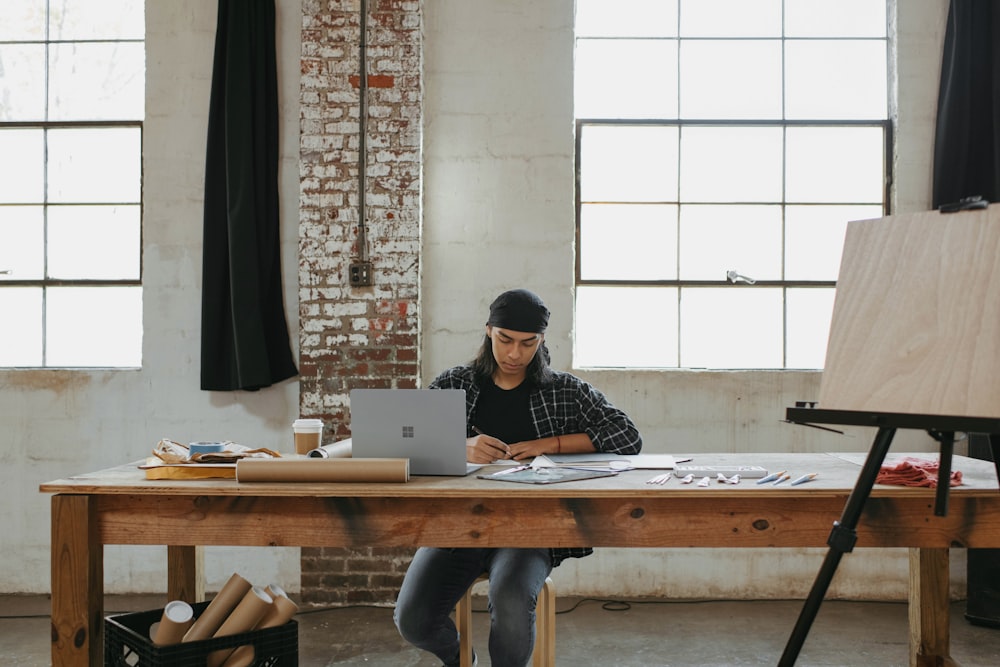 a man sitting at a table working on a laptop