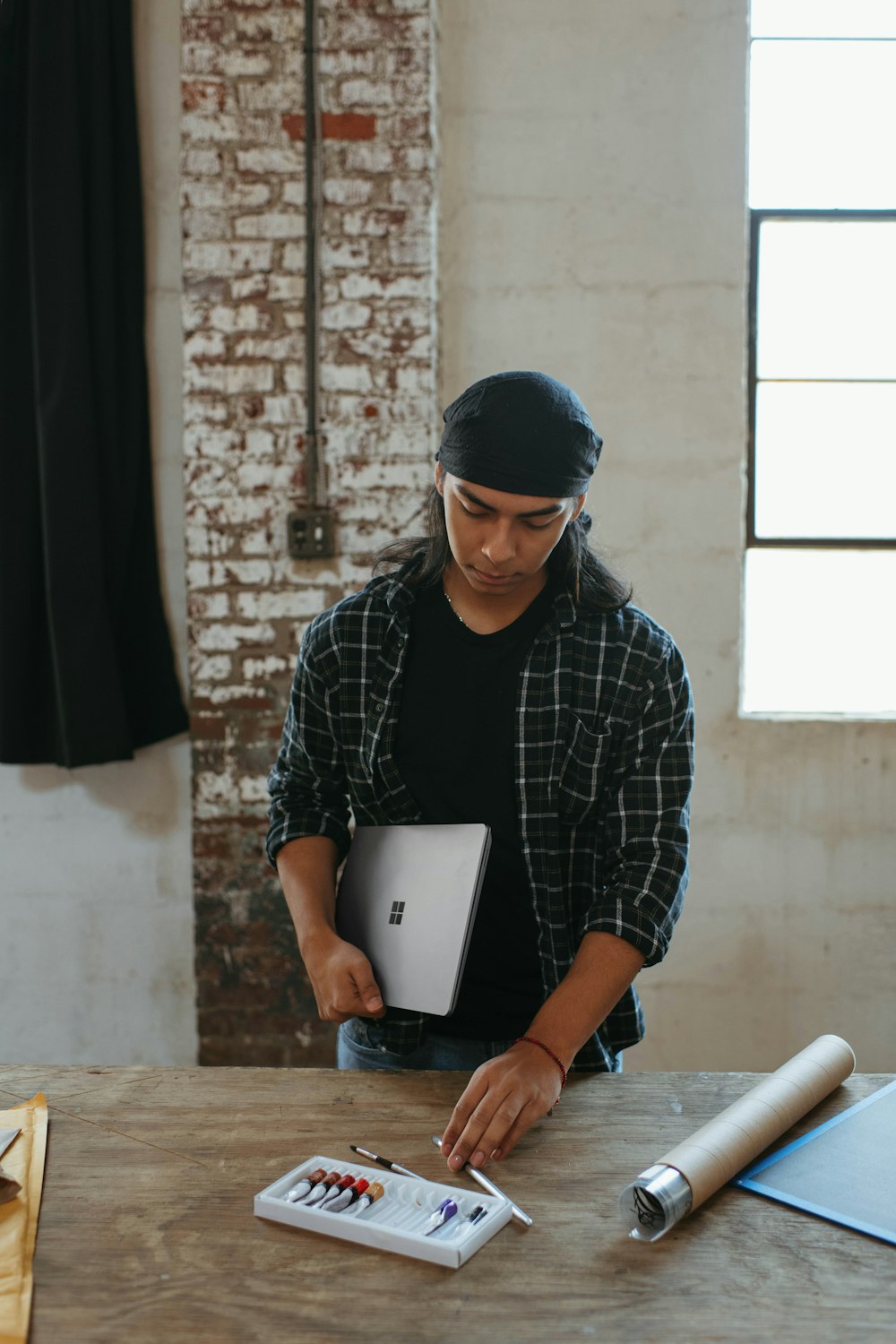 um homem em pé em uma mesa com um laptop