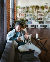 a man sitting on a couch holding a cup of coffee