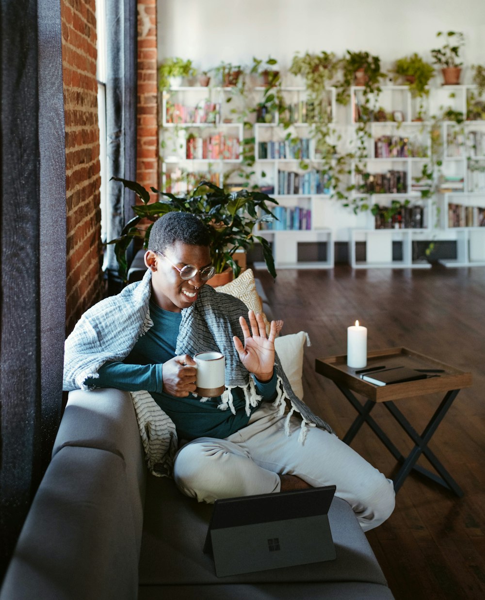 a man sitting on a couch holding a cup of coffee