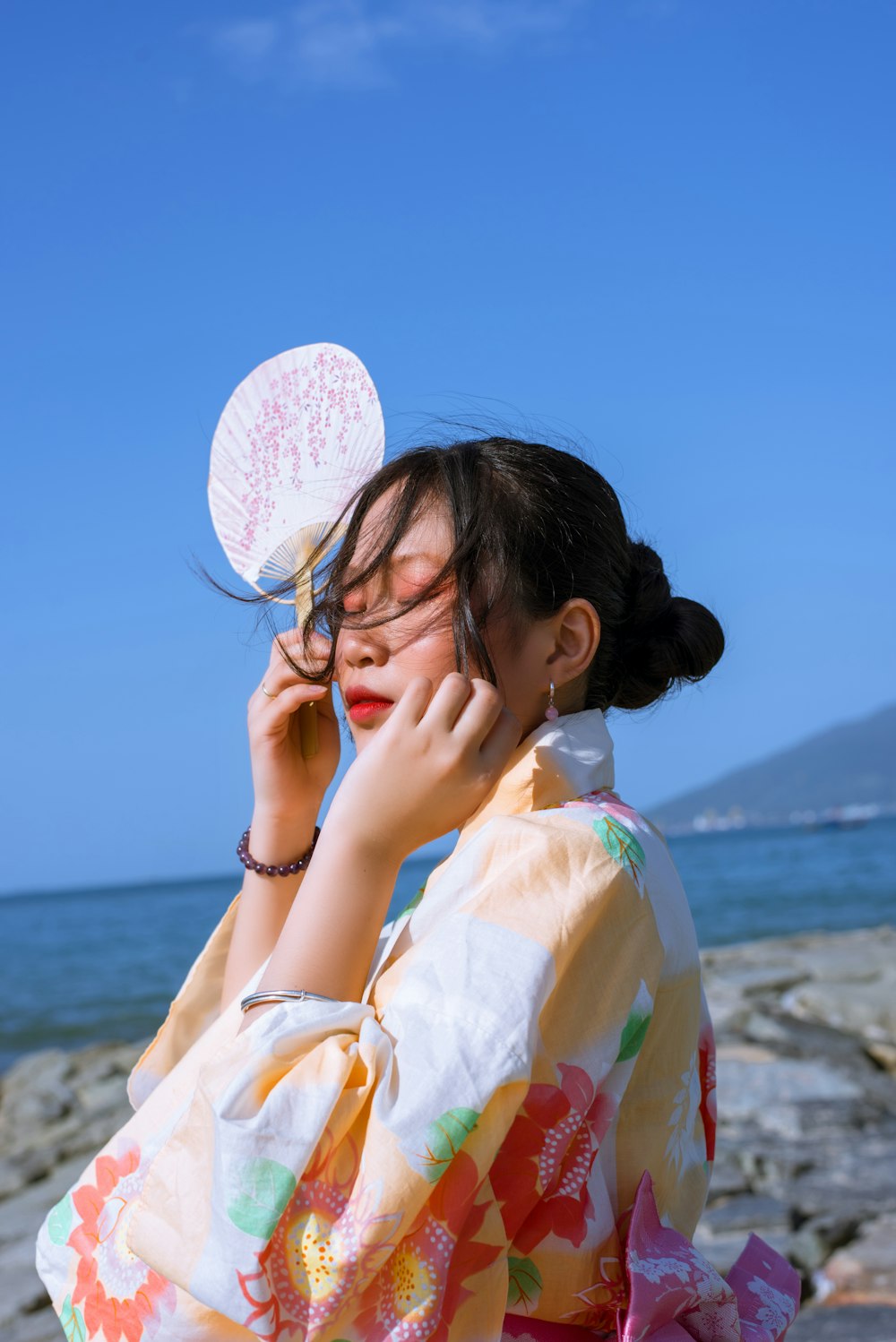 a woman in a kimono talking on a cell phone
