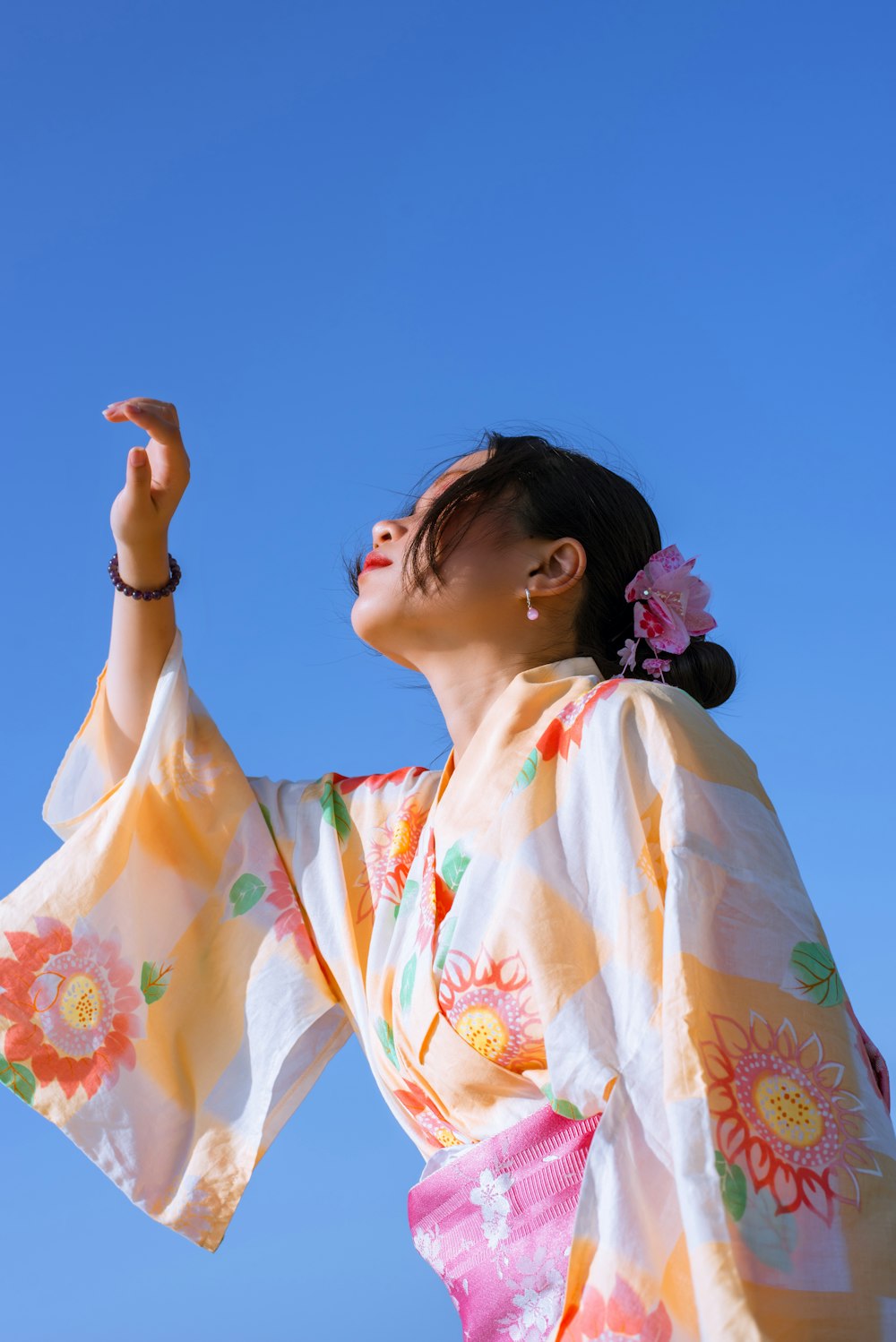 a woman in a kimono looking up into the sky