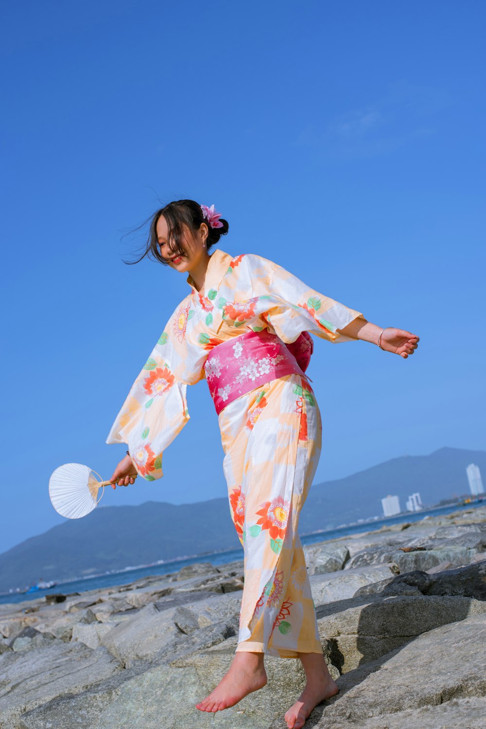 a woman in a kimono holding a frisbee