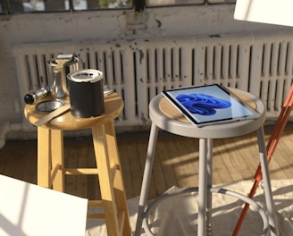 a tablet sitting on a stool next to a painting easel